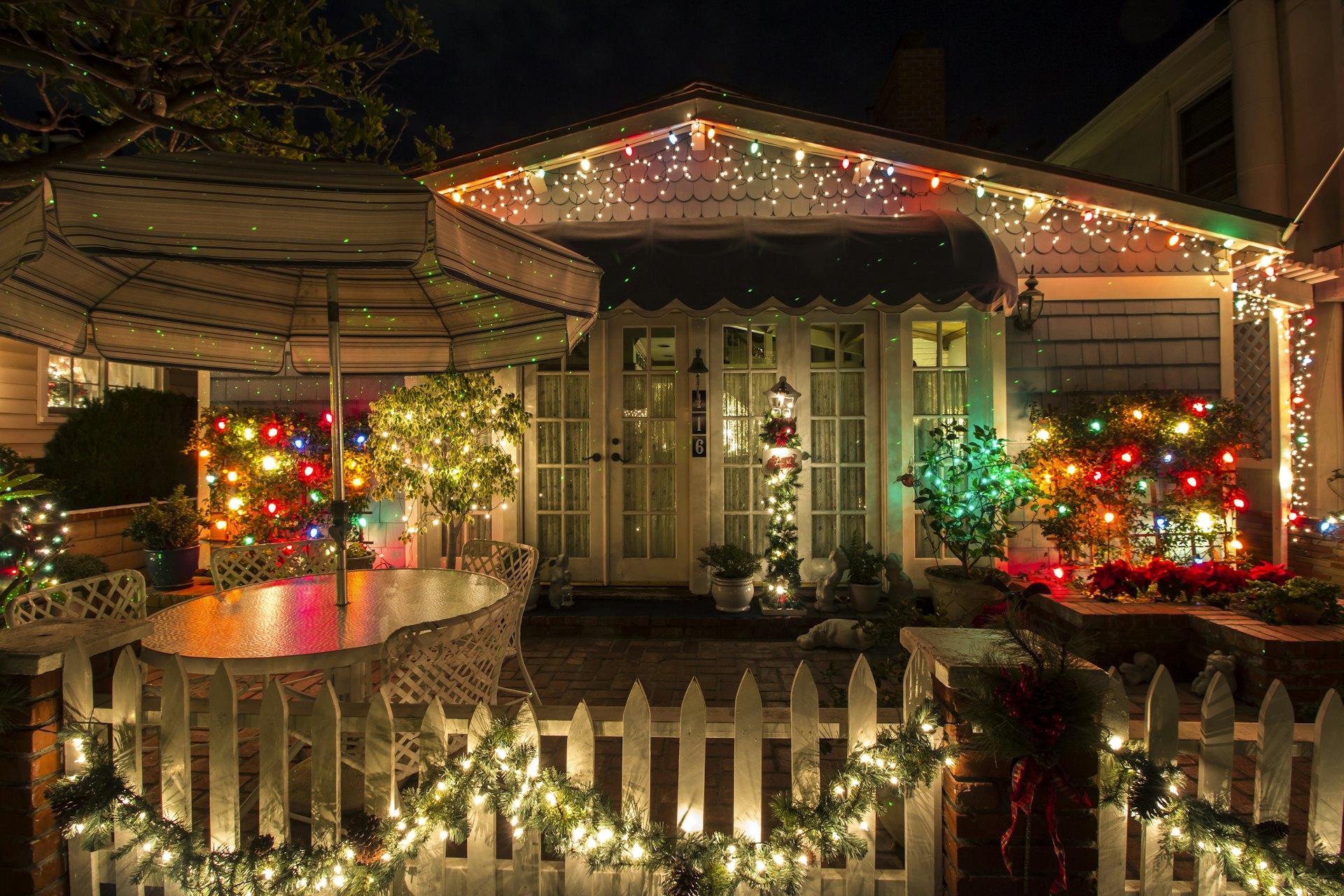 A mountain home decorated and glowing with holiday lights at night